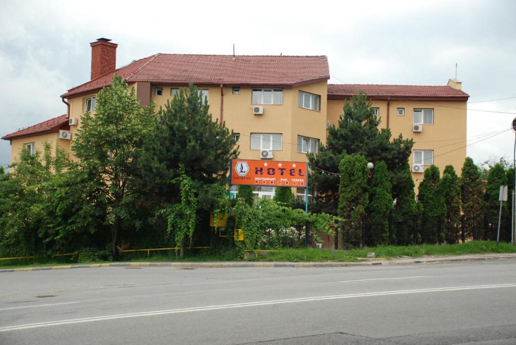 um edifício ao lado de uma estrada com árvores em Hotel Liliacul em Cluj-Napoca