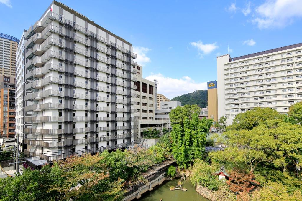 un grand bâtiment à côté d'une rivière avec des bâtiments dans l'établissement Hotel Monte Hermana Kobe Amalie, à Kobe