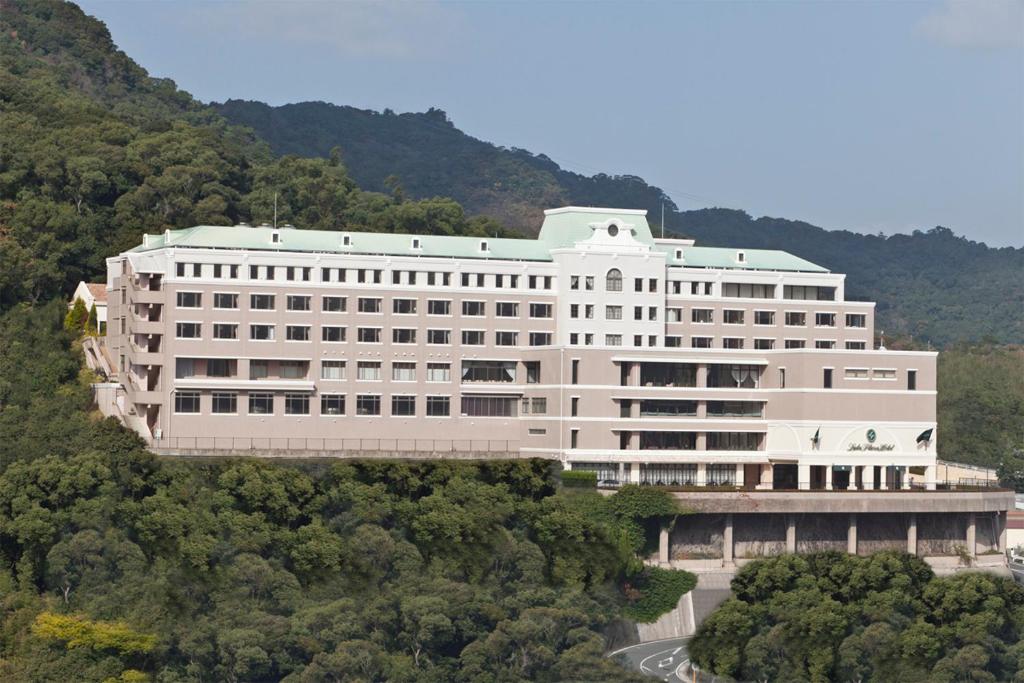 un grand bâtiment blanc au milieu d'une forêt dans l'établissement Luke Plaza Hotel, à Nagasaki