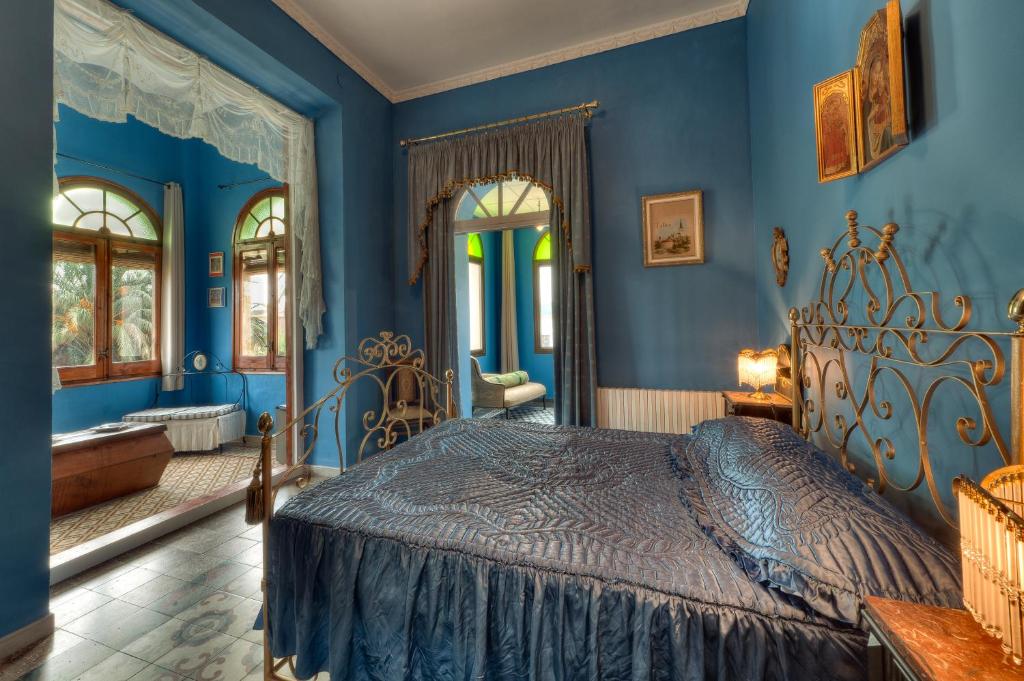 een slaapkamer met blauwe muren en een bed bij Hotel Casa Ceremines in Xerta