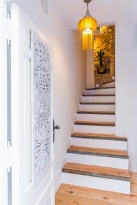 un escalier avec une porte blanche et un lustre dans l'établissement Blancos Rooms Hotel, à Peñíscola