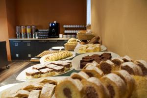 einen Tisch mit verschiedenen Arten von Kuchen und Gebäck in der Unterkunft Clarion Congress Hotel Olomouc in Olomouc