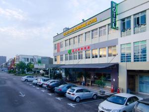 een groep auto's geparkeerd op een parkeerplaats voor een gebouw bij Eight Days Boutique Hotel - Mount Austin in Johor Bahru