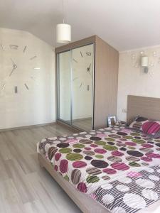 - une chambre avec un grand lit et une horloge murale dans l'établissement Villa Life, à Zatoka