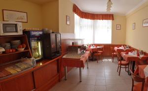 a dining room with tables and chairs in a restaurant at Hotel Central in Pécs