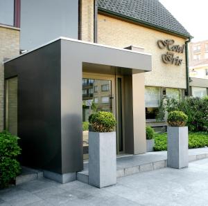 a entrance to a building with two potted plants at Hotel Iris in De Panne