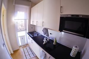 cocina con armarios blancos y encimera negra en 4YOU APARTMENTS - PONTI ROMANI en Padua