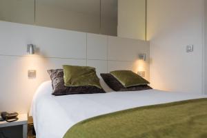 a bedroom with a white bed with two pillows at Hotel Expo in Brussels