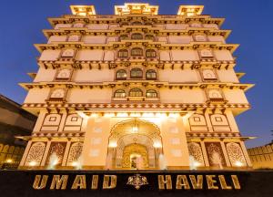 ジャイプールにあるUmaid Haveli-A Heritage Style Hotel & Resortの看板が目の前にある高層ビル