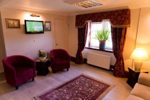 a living room with two chairs and a window at Leys Hotel in Aberdeen