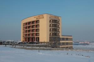 un grand bâtiment avec de la neige devant lui dans l'établissement Hotel Imperium, à Suceava