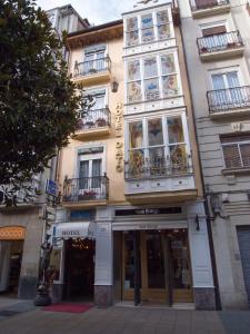 un alto edificio con finestre e balconi su strada di Hotel Dato a Vitoria-Gasteiz