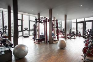 einen Fitnessraum mit Trainingsgeräten in einem Gebäude mit Fenstern in der Unterkunft Crans Ambassador in Crans-Montana