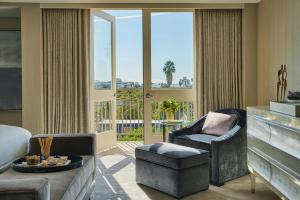 a living room with a couch and chairs and a piano at L'Ermitage Beverly Hills in Los Angeles