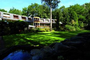 un edificio con un patio con un estanque delante de él en Fletcher Hotel-Restaurant De Scheperskamp en Lochem