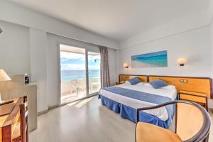 een hotelkamer met een bed en uitzicht op de oceaan bij Hotel Voramar in Cala Millor