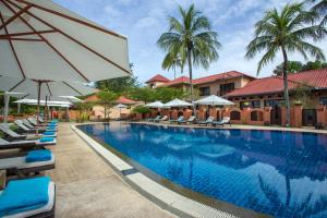 una gran piscina con tumbonas y sombrillas en Casa del Mar Langkawi, en Pantai Cenang