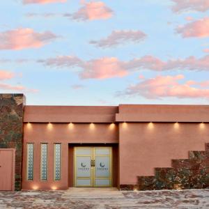 ein Gebäude mit zwei Türen und einem wolkigen Himmel in der Unterkunft Yakana Hotel in San Pedro de Atacama