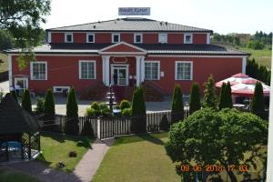 een rood huis met een hek ervoor bij Hotelik Karter in Warschau