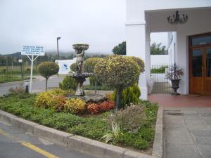 een tuin voor een gebouw met een fontein bij Mount Currie Inn in Kokstad