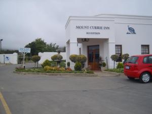 een rood busje geparkeerd voor een North Carnegie Inn bij Mount Currie Inn in Kokstad