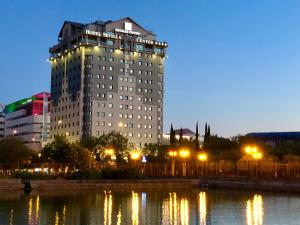 a large building with lights in front of a body of water at Hotel Sevilla Center in Seville