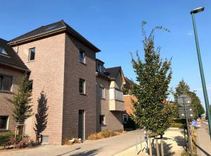 een groot bakstenen gebouw met een boom ervoor bij Casa Akuta Airport Flat in Kortenberg