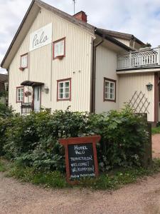 un bâtiment avec un panneau devant lui dans l'établissement Hotel Palo, à Naantali