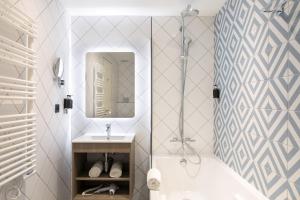 a bathroom with a tub and a sink and a mirror at The Deck Hotel by Happyculture in Nice