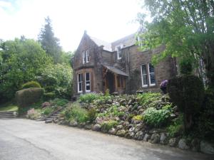 an old stone house with a garden in front of it at Ormidale Hotel in Brodick