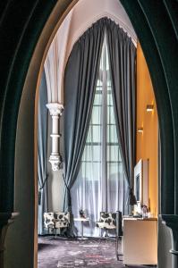 an arched hallway with a large window with curtains at Martin's Dream Hotel in Mons