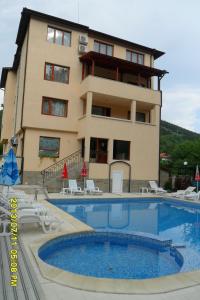 un bâtiment avec une piscine en face d'un bâtiment dans l'établissement Family Prim Hotel, à Sandanski