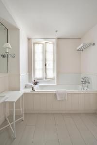 a white bathroom with a tub and a window at Villa Clarisse & Spa by Olivier Claire in Saint-Martin-de-Ré