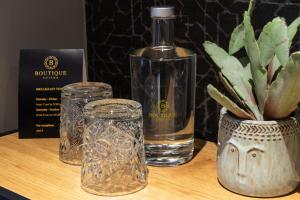 een fles water en glazen op een tafel bij Boutique Suites Lisse - Schiphol in Lisse