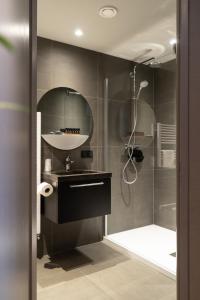 een badkamer met een douche, een wastafel en een spiegel bij Boutique Suites Lisse - Schiphol in Lisse