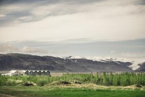 pole z domem i górami w tle w obiekcie Fosshótel Vatnajökull w mieście Höfn