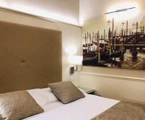 una camera da letto con un letto e un dipinto sul muro di San Lio Tourist House a Venezia