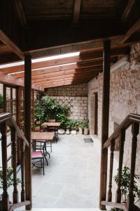 a patio with tables and chairs and a stone wall at Kentrikon in Ioannina