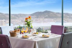 - une table avec des assiettes de nourriture et une vue sur l'océan dans l'établissement Luke Plaza Hotel, à Nagasaki