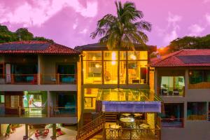 a building with a palm tree in front of it at Hotel Vila Kebaya in Ilhabela