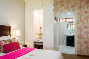 1 dormitorio con 1 cama y baño con ducha en Glen Ormond Country House, en Henburg Park