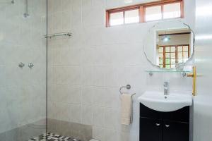 y baño con lavabo y ducha acristalada. en Glen Ormond Country House, en Henburg Park