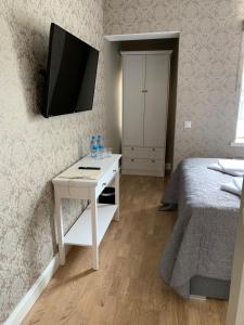 um quarto com uma cama e uma secretária com uma televisão na parede em Rohuaia Apartments em Rakvere