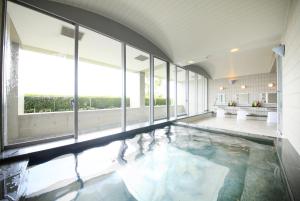 - une grande piscine avec des baies vitrées dans un bâtiment dans l'établissement TOTO Seawind Awaji, à Awaji