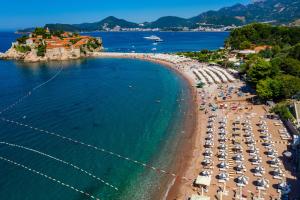 una vista aérea de una playa con sillas y sombrillas en Hotel California by Aycon en Sveti Stefan