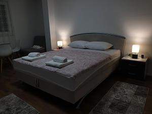 um quarto com uma cama com toalhas em Apartmani HM em Trebinje