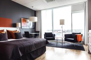 1 dormitorio con cama, sillas y mesa en Sky Hotel Apartments Tornet en Linköping