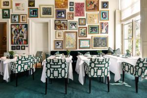 a dining room with two tables and a wall of pictures at Hotel Van Cleef in Bruges