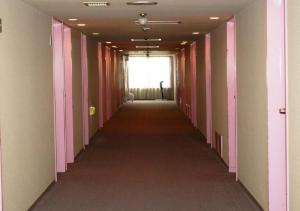 a long hallway with pink and white walls and a window at skyhotel uozu / Vacation STAY 59577 in Uozu