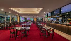 um restaurante com mesas e cadeiras e um bar em Palms Hotel em Sidney